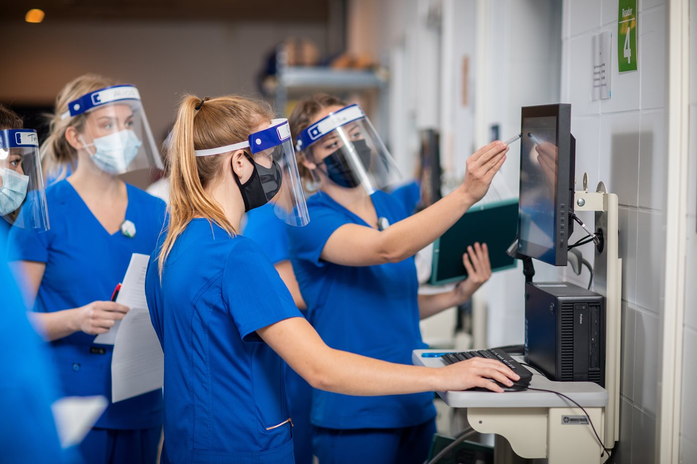 NAIT School of Health Sciences students wear face shields to learn in lab.
