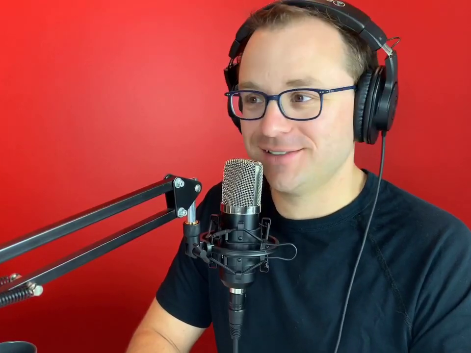Michael Turcsanyi in front of a microphone recording a podcast.