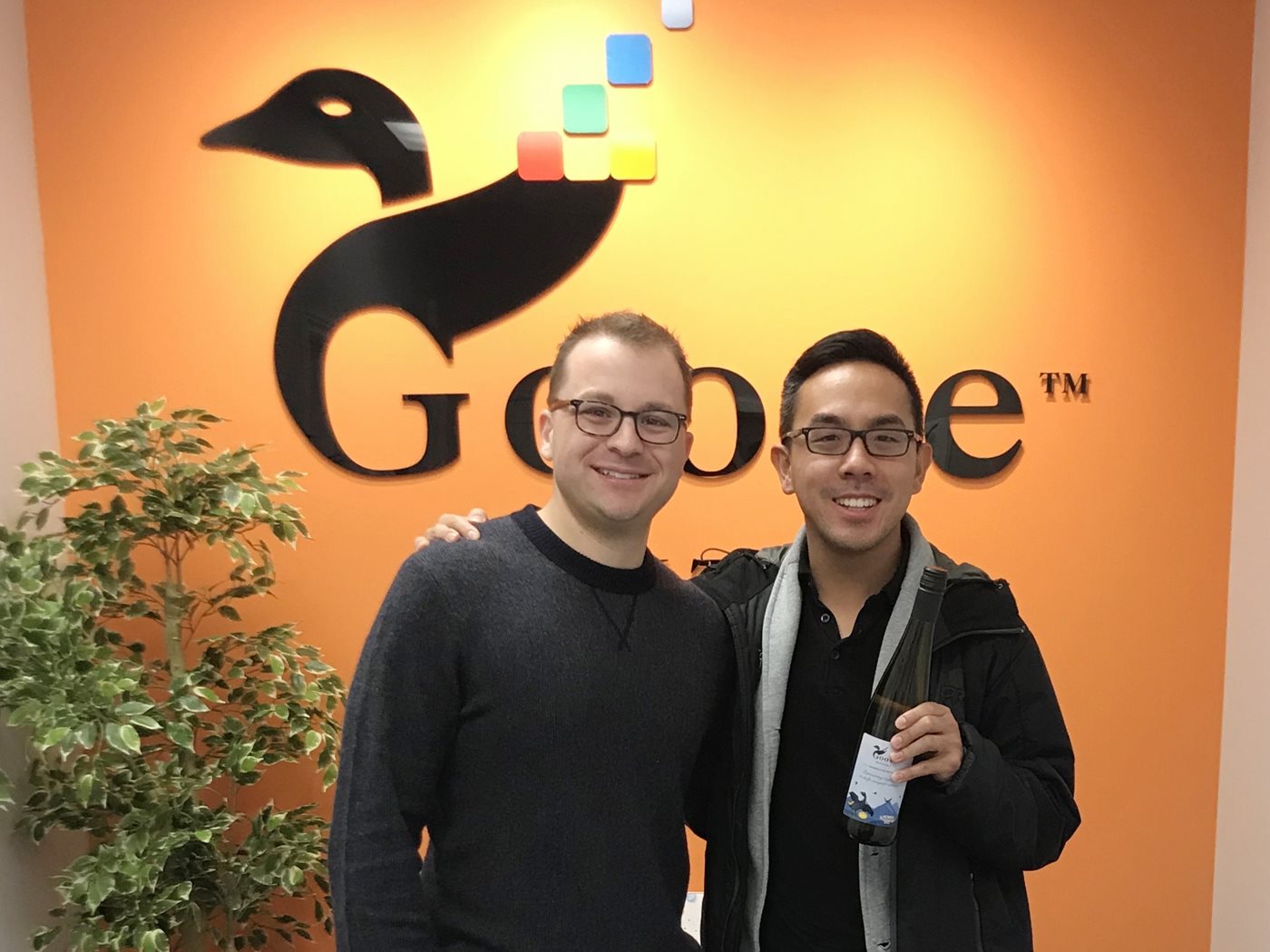 Michael Turcsanyi and a colleague stand in front of the Goose Digital logo in the Toronto, Ontario, office.