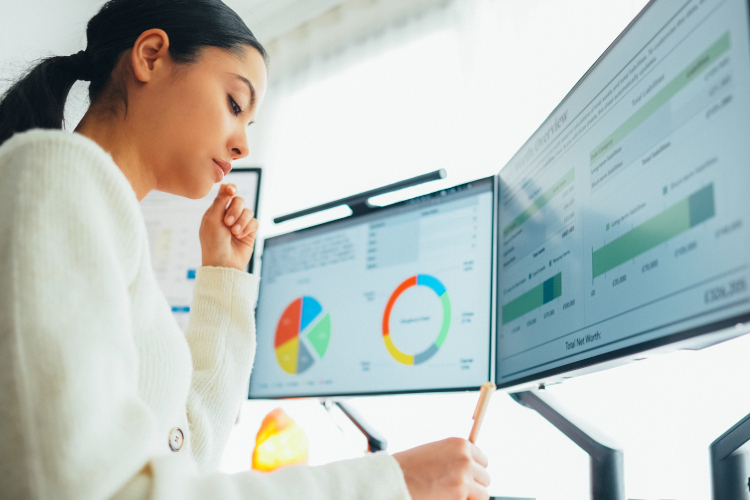 student working on a desktop computer looking at data and analytics