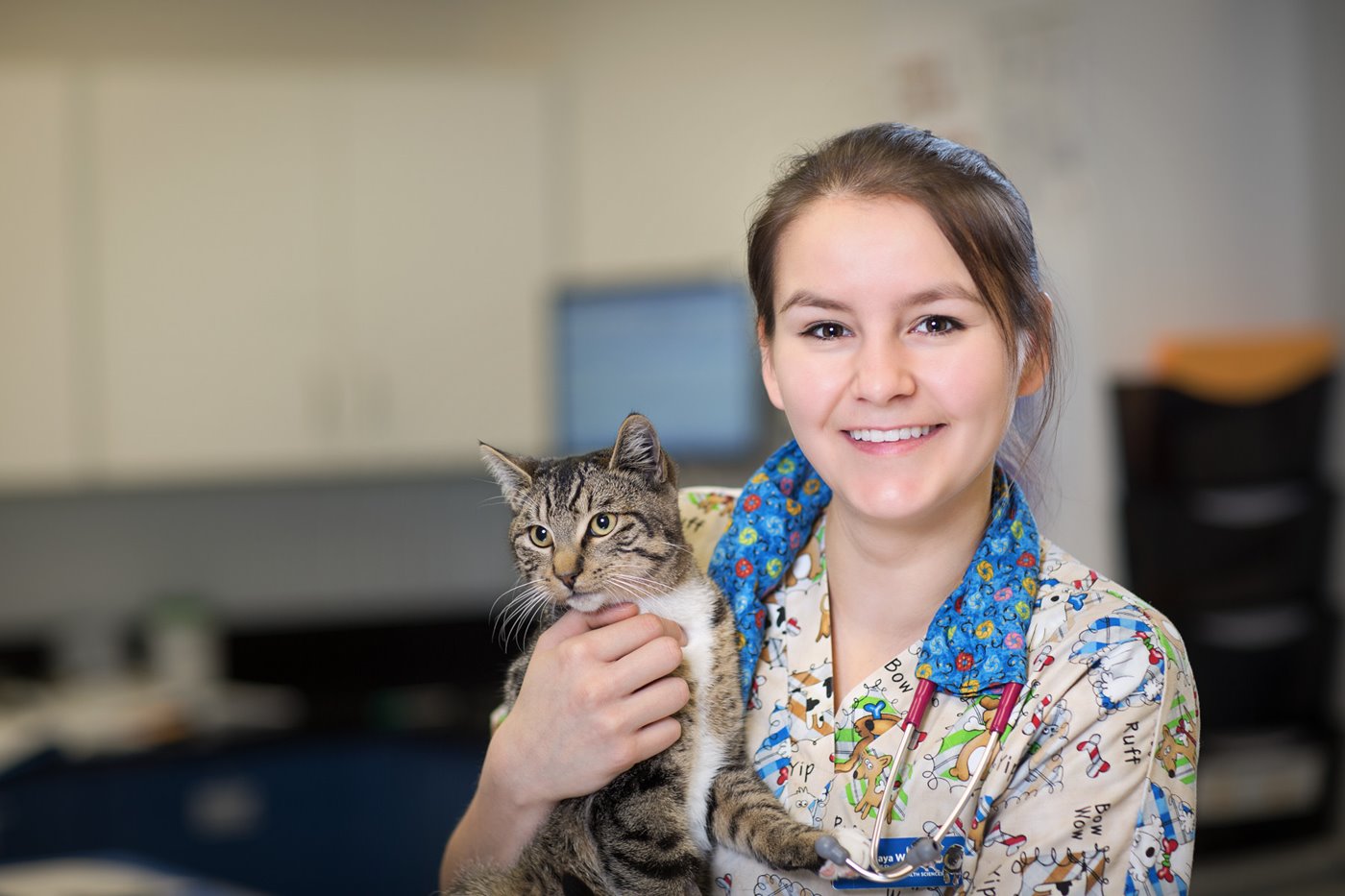 Animal Health student with kitten in lab.