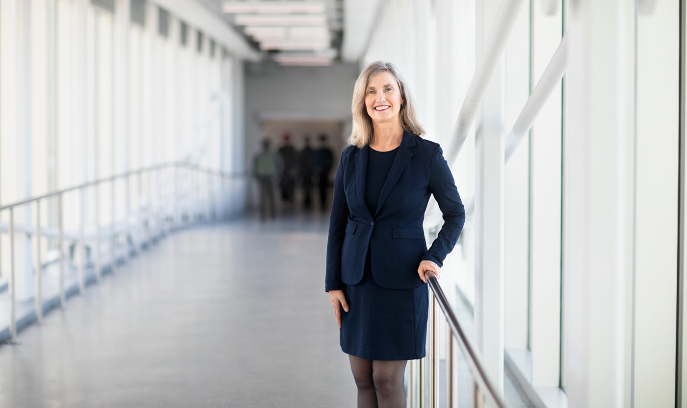 NAIT President and CEO Laura Jo Gunter wearing a black suit and standing in a pedway.