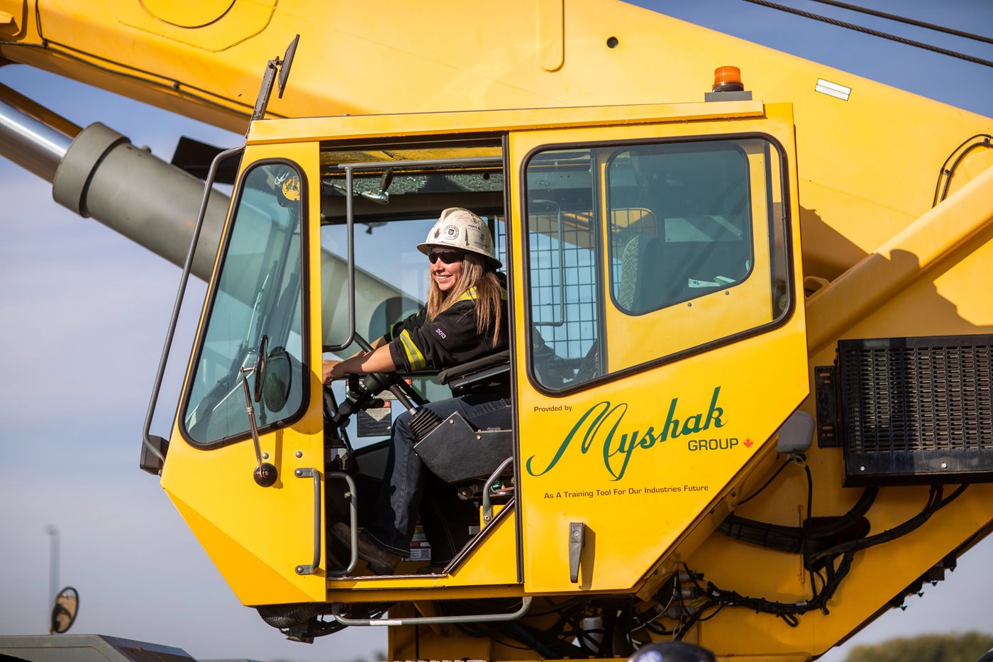 Female in crane hoisting operating crane